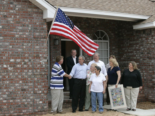 President George W. Bush shakes hands with Ernie Woodward of Long Beach, Miss. after Woodward, joined by his family, raised a flag given to them by President Bush outside his home Thursday, March 1, 2007, during the President’s tour of the neighborhood where some homes damaged by Hurricane Katrina have been rebuilt with Gulf Coast grant money. White House photo by Eric Draper