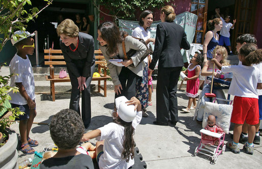 Mrs. Laura Bush talks with a little boy at Projeto Aprendiz Friday, March 9, 2007, in Sao Paolo, Brazil. Developing the concept of the neighborhood as a school, the program supplements school education with a wide range of community-based activities that nurture young people’s creativity and self-esteem. White House photo by Shealah Craighead