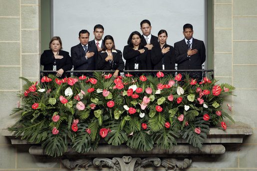Staff members stand for the playing of the national anthems Monday, March 12, 2007, during the arrival ceremony at the Palacio Nacional de la Cultura in Guatemala City, marking the visit of President George W. Bush and Mrs. Laura Bush to the country. White House photo by Paul Morse