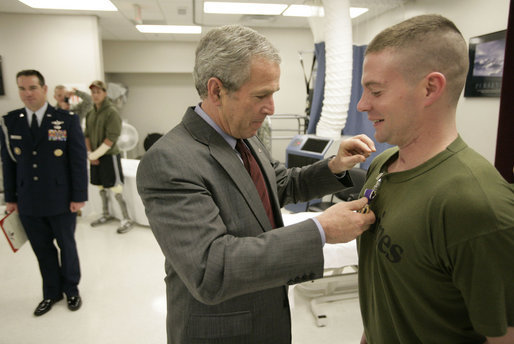 President George W. Bush presents the Purple Heart to U.S. Marine Lance Cpl. Joshua Ryan Bleill of Greenfield, Ind., during a visit Friday, March 30, 2007, to the Walter Reed Army Medical Center in Washington, D.C. Bleill is recovering from injuries sustained in Operation Iraqi Freedom. White House photo by Eric Draper