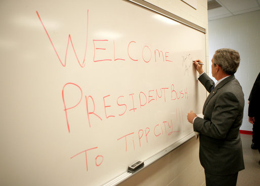 President George W. Bush signs a dry erase board with a permanent marker as he passes through a locker room during his visit to Tipp City High School in Tipp City, Ohio, Thursday, April 19, 2007. White House photo by Eric Draper