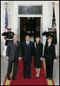 President George W. Bush and Mrs. Laura Bush stand for press photographs with Japanese Prime Minister Shinzo Abe and his wife Mrs. Akie Abe Thursday, April 26, 2007, as they arrive at the North Portico for a social dinner at the White House. White House photo by Shealah Craighead