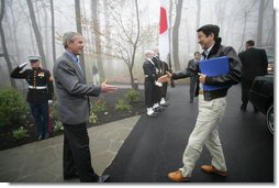 President George W. Bush reaches out to welcome Prime Minister Shinzo Abe to Camp David Friday, April 27, 2007. The leaders are expected to discuss their close cooperation in global affairs. White House photo by Eric Draper