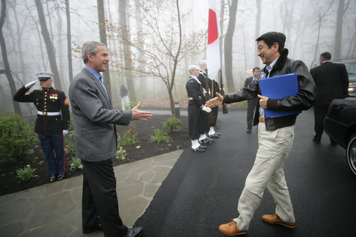 President George W. Bush reaches out to welcome Prime Minister Shinzo Abe to Camp David Friday, April 27, 2007. The leaders are expected to discuss their close cooperation in global affairs. White House photo by Eric Draper