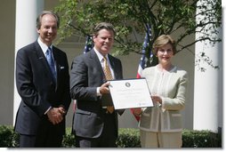 Mrs. Laura Bush presents a plaque to John McLaughlin, center, president and CEO of the USS Midway Museum in San Diego, Calif., and Scott McGaugh, marketing director of the museum, honoring them with a 2007 Preserve America Presidential Award in the Rose Garden at the White House Wednesday, May 9, 2007.  White House photo by Joyce Boghosian
