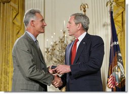President George W. Bush congratulates military spouse Michael Winton of Wright-Patterson Air Force Base, Ohio, as Winton is presented with the President’s Volunteer Service Award Thursday, May 10, 2007, in the East Room of the White House during a celebration of Military Spouse Day. White House photo by Eric Draper