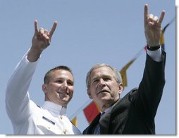 President George W. Bush and U.S. Coast Guard graduate Brian Robert Staudt offer the Texas Longhorns hand sign out to the audience following the President’s address to the graduates Wednesday, May 23, 2007, at the U.S. Coast Guard Academy commencement in New London, Conn. White House photo by Joyce N. Boghosian