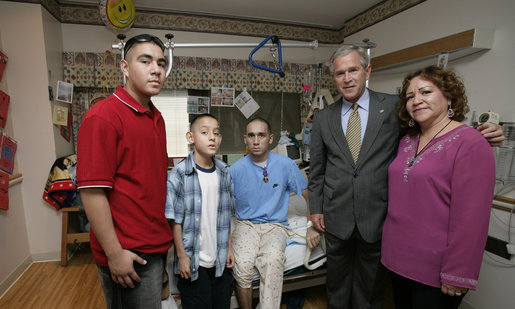 President George W. Bush stands with Cpl. Manuel Provencio of Tucson, after awarding him a Purple Heart Friday, May 25, 2007, during a visit to the National Naval Medical Center in Bethesda, Md., where the Marine is recovering from wounds received in Operation Iraqi Freedom. With them are Cpl. Provencio's mother, Manuela, and brothers, Carlos, in red, and Angel. White House photo by Joyce N. Boghosian