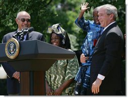 President George W. Bush holds Baron Mosima Loyiso Tantoh in the Rose Garden of the White House Wednesday, May 30, 2007, after delivering a statement on PEPFAR, the President's Emergency Plan for AIDS Relief. With them are the boy's mother, Kunene Tantoh, representing Mothers to Mothers, which provides treatment and support services for HIV-positive mothers in South Africa, and Dr. Jean "Bill" Pape, internationally recognized for his work with infectious diseases.  White House photo by Chris Greenberg