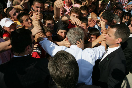 President George W. Bush is covered with the hands of Albanians has he's greeted with an outpouring of welcome Sunday, June 10, 2007, during a stop in Fushe Kruje. The stop marked the first time a sitting U.S. president has visited the country. White House photo by Eric Draper
