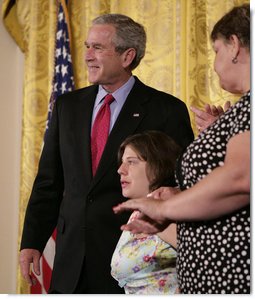 President George W. Bush embraces stem cell patient Kaitlyne McNamara following his address on the reasons he vetoed S.5, the “Stem Cell Research Enhancement Act of 2007,” in the East Room of the White House Wednesday, June 20, 2007. McNamara was born with spina bifida, a disease that damaged her bladder, her doctors isolated healthy stem cells in a piece of her own bladder and used them to grow her a new bladder.  White House photo by Eric Draper
