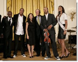 President George W. Bush thanks entertainers, from left to right, KEM, Tourie Escobar, Karina Pasian, Damien Escobar and Miss USA Rachel Smith on stage Friday, June 22, 2007 in the East Room of the White House, for their participation in a celebration of Black Music Month at the White House. White House photo by Eric Draper