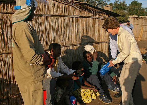 Mrs. Laura Bush hands out insecticide-treated malaria nets during a visit to a malaria spraying site Wednesday, June 27, 2007, in Mozal, Mozambique. In 2005, President Bush created the President's Malaria Initiative, an interagency effort, with a budget of $30 million. Since then the President has commited an additional $1.2 billion to the program. White House photo by Shealah Craighead