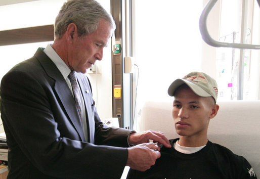 President George W. Bush pins a Purple Heart on Cpl. Joel Dulashanti of Cincinnati, during a visit Tuesday, July 3, 2007, to Walter Reed Army Medical Center in Washington, D.C., where the soldier is recovering from wounds received in Operation Iraqi Freedom. White House photo by Eric Draper