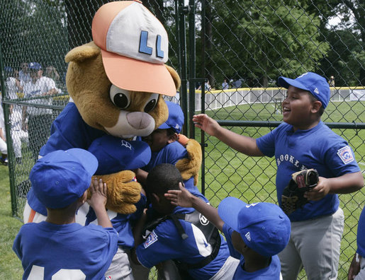 Players from the Inner City Little League of Brooklyn, N.Y. give a group hug to Dugout, the Little League mascot Sunday, July 15, 2007 at the White House Tee Ball Game, played in honor of baseball legend Jackie Robinson between Inner City and the Wrigley Little League Dodgers of Los Angeles. More about Tee Ball on the South Lawn. White House photo by Joyce N. Boghosian