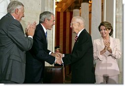 President George W. Bush congratulates Dr. Norman Bourlag during the Congressional Gold Medal Ceremony honoring the doctor's efforts to combat hunger Tuesday, July 17 , 2007, at the U.S. Capitol. Also pictured is House Majority Leader Steny Hoyer, right, and Speaker of the House Nancy Pelosi. White House photo by Chris Greenberg