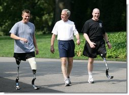President George W. Bush meets with wounded veterans U.S. Army Sgt.Neil Duncan (Ret.), left, and U.S. Army Specialist Max Ramsey, right, for a jog Wednesday, July 25, 2007 around the South Lawn of the White House. White House photo by Eric Draper