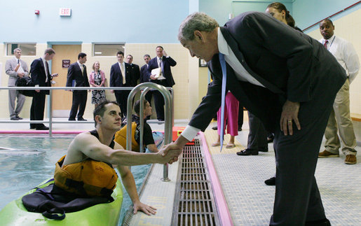 President George W. Bush meets wounded veteran Peter J. Rooney III of Cummington, Mass., a participant in the Team River Runner aquatic therapy program, during the President’s visit Monday, Aug. 13, 2007 to the Washington, D.C. Veterans Affairs Medical Center indoor pool, where recuperating wounded veterans use kayaks to learn and increase their mobile skills. Team River Runner is an all-volunteer organization established in 2004 by kayakers in the Washington area that uses recreation rehabilitation through aquatic therapy activities. White House photo by Chris Greenberg
