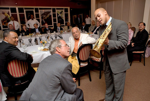 Trumpeter Irvin Mayfield shows President George W. Bush the Elysian Trumpet during a dinner with cultural and community leaders Tuesday, Aug. 28, 2007, at Dooky Chase Restaurant in New Orleans, La. Dedicated to those who perished in Hurricane Katrina, the trumpet is named for the neighborhood where Mr. Mayfield's father drowned during the storm. Representing New Orlean's spirit, the instrument is decorated with symbols of the city. White House photo by Chris Greenberg
