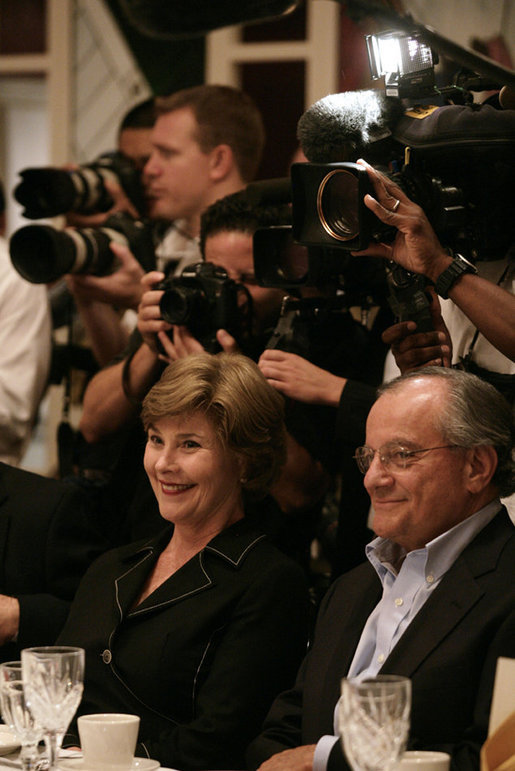 Mrs. Laura Bush and fellow dinner guest Joe Canizaro, president and CEO of Columbus Properties of New Orleans, are backed by news cameras during a dinner with Louisiana cultural and community leaders Tuesday evening, Aug. 28, 2007, at Dooky Chase's restaurant in New Orleans. President George W. Bush and Mrs. Laura Bush are visiting New Orleans and the Gulf Coast region on the second anniversary of Hurricane Katrina. White House photo by Shealah Craighead