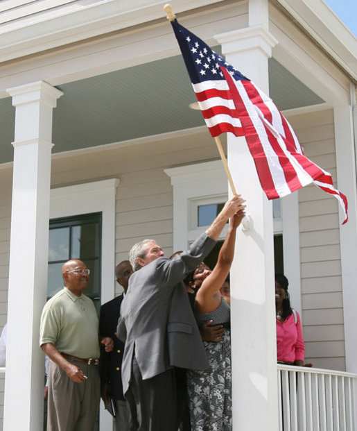 President George W. Bush helps hang a flag outside the new home of Gen White, Wednesday, Aug. 29, 2007, at a new housing development in New Orleans, during President Bush’s visit to New Orleans and the Gulf Coast region on the second anniversary of Hurricane Katrina. U.S. Secretary of Housing and Urban Development Alphonso Jackson is seen at left. White House photo by Shealah Craighead