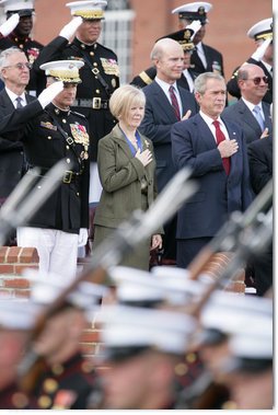 President George W. Bush stands with outgoing Joint Chiefs of Staff Chairman U.S. Marine General Peter Pace and Pace's wife, Lynne Pace, center, as troops pass in review during the Armed Forces farewell tribute in honor of General Pace and the Armed Forces hail in honor of the new Joint Chiefs of Staff Chairman Navy Admiral Michael Mullen, Monday, October 1, 2007 at Fort Myer, Virginia. White House photo by Chris Greenberg