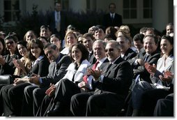 President George W. Bush joins the Rose Garden audience during a celebration Wednesday, Oct. 10, 2007, of Hispanic Heritage Month at the White House. Sitting with the President is Yamile Llanes Labrada, the wife of a political prisoner in Cuba, and Emilio Estefan. White House photo by Eric Draper