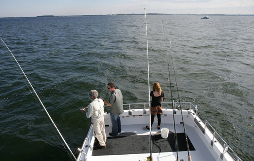 President George W. Bush, left, is seen fishing aboard a fishing boat Saturday, Oct. 20, 2007 off the coast of St. Michaels, Md., in the Chesapeake Bay, for a television interview with Chris and Melissa Fischer, hosts of ESPN’s Offshore Adventures, where President Bush talked about his love of the outdoors and his signing of an Executive Order earlier in the day to protect striped bass and red drum fish species. White House photo by Eric Draper