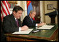 President George W. Bush and President Nambaryn Enkhbayar of Mongolia sign the Millennium Challenge Corporation Compact Monday, Oct. 22, 2007, in the Roosevelt Room of the White House. White House photo by Chris Greenberg
