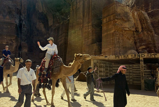 Mrs. Laura Bush takes a ride on a camel while touring Petra, an ancient city in southern Jordan Friday, Oct. 26, 2007. In 1997, a carved relief depicting two pairs of camels and camel drivers were discovered at the entrance of the city. During its time, Petra was a caravan city and trading center for the entire region. White House photo by Shealah Craighead