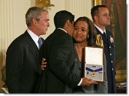 President George W. Bush presents the Presidential Medal of Freedom to Yan Valdes Morejon and Winnie Biscet in honor of their father Oscar Elias Biscet during a ceremony Monday, Nov. 5, 2007, in the East Room. "Oscar Biscet is a healer -- known to 11 million Cubans as a physician, a community organizer, and an advocate for human rights," said the President about the imprisoned physician. "The international community agrees that Dr. Biscet's imprisonment is unjust, yet the regime has refused every call for his release." White House photo by Joyce N. Boghosian