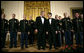 President George W. Bush and President Nicolas Sarkozy of France stand on stage with the Army Chorus in the East Room of the White House Tuesday, Nov. 6, 2007, following the after-dinner performance by the 22-member group. White House photo by Eric Draper