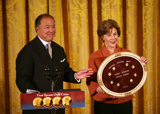 Mrs. Laura Bush and U.S. Mint Director Ed Moy hold up the Dolley Madison Gold Coin Monday, Nov. 19, 2007, in the East Room. "Today, we're paying tribute to an amazing First Lady, and an extraordinary woman, with the Dolley Madison Gold Coin," said Mrs. Bush. "Over the last year, since the U.S. Mint launched the First Ladies series, these coins have been extremely popular: The likenesses of Martha Washington, Abigail Adams, and Jefferson's Lady Liberty sold out within hours of their release. Their appeal reflects the enthusiasm of America's coin collectors, the public's fascination with American history, and Americans' interest in our remarkable First Ladies." White House photo by Joyce N. Boghosian