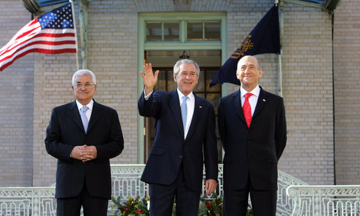 President George W. Bush waves to photographers as he stands with Palestinian President Mahmoud Abbas, left, and Prime Minister Ehud Olmert Tuesday, Nov. 27, 2007, at the Annapolis Conference in Annapolis, Maryland. White House photo by Chris Greenberg