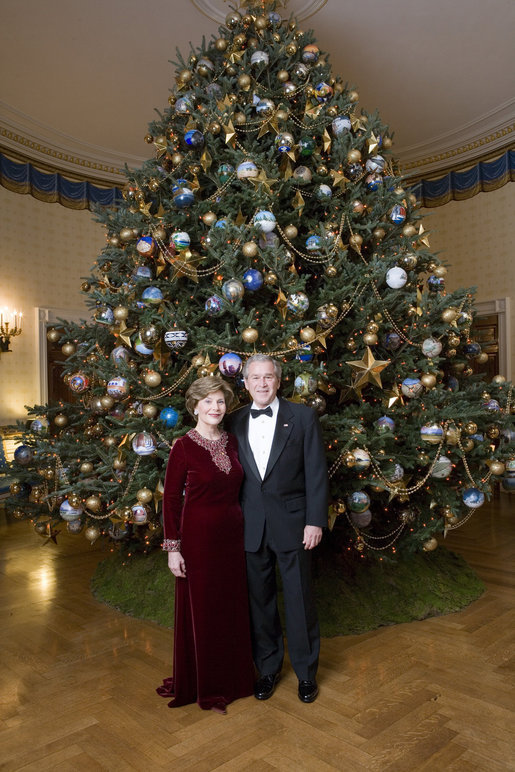 Celebrating the 2007 holiday season, President George W. Bush and Mrs. Laura Bush pose in front of the Christmas Tree in the Blue Room of the White House. White House photo by Eric Draper