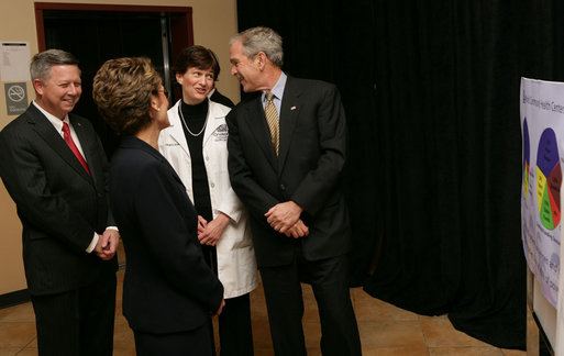 President George W. Bush shares a moment with Nebraska Gov. Dave Heineman, Andrea Skolkin and Kristine McVea, in lab coat, before his tour Wednesday, Dec. 5, 2007, of the OneWorld Community Health Centers Inc. in Omaha. White House photo by Chris Greenberg