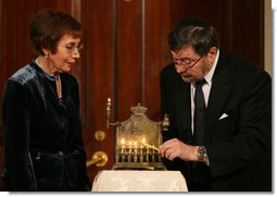 A Menorah belonging to the great-grandfather of Daniel Pearl is lit by Judea and Ruth Pearl, his parents, during festivities Monday, Dec. 10, 2007, in the Grand Foyer of the White House. Said the President of the slain journalist, "His only crime was being a Jewish American -- something Daniel Pearl would never deny. Daniel's memory remains close to our hearts. By honoring Daniel, we are given the opportunity to bring forth hope from the darkness of tragedy-- and that is a miracle worth celebrating during the Festival of Lights." White House photo by Joyce N. Boghosian