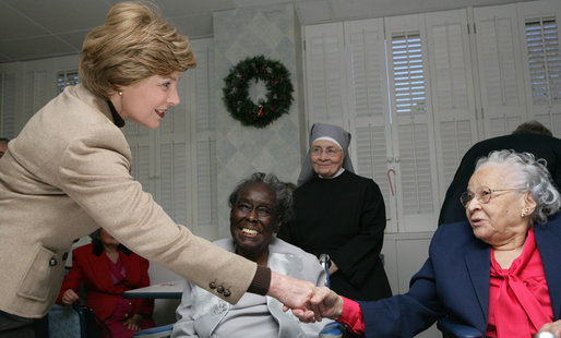 Mrs. Laura Bush reaches out for the hand of a resident of the Little Sisters of the Poor during a visit Tuesday, Dec. 18, 2007, with President George W. Bush to the Washington, D.C. facility that provides nursing and assisted living services to elderly people of lesser means. White House photo by Chris Greenberg