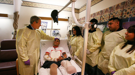 President George W. Bush speaks with U.S. Marine Cpl. Zachary Briseno of Fort Worth, Texas, at the National Naval Medical Center in Bethesda, Md., Wednesday, Dec. 19, 2007, after being awarded a Purple Heart medal and citation. Cpl. Briseno, joined by members of his family from left, Briseno's mother, Mariana; brothers, Roman and Tony; and Briseno's girlfriend, Jennifer Rangel, is recovering from injuries sustained in Operation Iraqi Freedom. White House photo by Joyce N. Boghosian
