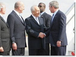 President George W. Bush is greeted by Israel’s President Shimon Peres, center, and Prime Minister Ehud Olmert after arriving in Tel Aviv Wednesday, Jan. 9, 2008, for a weeklong visit to the Mideast.  White House photo by Eric Draper