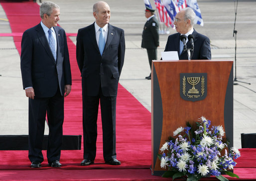 Israel’s President Shimon Peres speaks to President George W. Bush during remarks Wednesday, Jan. 9, 2008, at ceremonies welcoming him to Israel. With them is Israeli Prime Minister Ehud Olmert, center. White House photo by Chris Greenberg