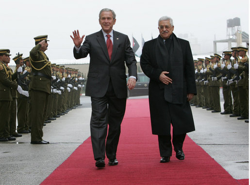 President George W. Bush waves as he and President Mahmoud Abbas of the Palestinian Authority walk the red carpet after the arrival Thursday, Jan. 10, 2008, of President Bush to Ramallah. White House photo by Chris Greenberg