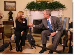 President George W. Bush holds the hand of Elsa Morejon, wife of Presidential Medal of Freedom recipient and human rights activist Oscar Biscet, who is currently being held in a Cuban prison, during a meeting welcoming Morejon to the Oval Office, Thursday, Jan. 24, 2008. White House photo by Eric Draper
