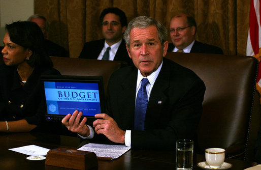 President George W. Bush holds up a computer with the E-Budget for the cameras during a Cabinet meeting Monday, Feb. 4, 2008.