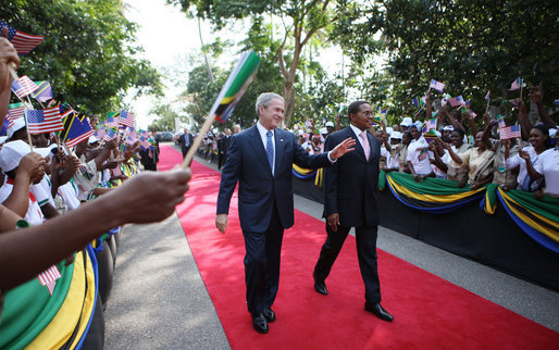 President George W. Bush and President Jakaya Kikwete of Tanzania acknowledge the crowd as they walk through the ceremonial arrival cordon Sunday, Feb. 17, 2008, at the State House in Dar es Salaam. White House photo by Eric Draper