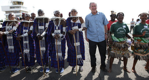 President George W. Bush is welcomed by Maasai dancers on his arrival Monday, Feb. 18, 2008 to the airport in Arusha, Tanzania. White House photo by Eric Draper