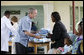 President George W. Bush presents a mosquito net to a patient during a tour Monday, Feb. 18, 2008, of the Meru District Hospital outpatient clinic in Arusha, Tanzania. The mosquito nets are part of a program to help in the battle against malaria. White House photo by Eric Draper