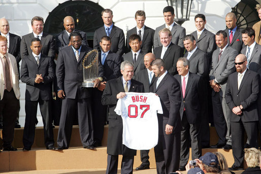 President George W. Bush is presented with a personalized Boston Red Sox jersey from team captain Jason Varitek, as President Bush honored the 2007 World Series Champions Wednesday, Feb. 27, 2008, on the South Lawn of the White House. White House photo by Joyce N. Boghosian