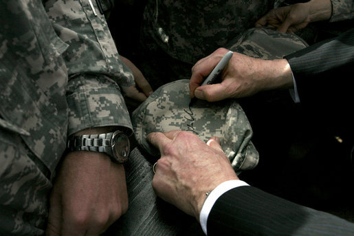 Vice President Dick Cheney autographs a hat during a rally for the troops Tuesday, March 18, 2008, at Balad Air Base, Iraq. White House photo by David Bohrer