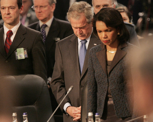President George W. Bush bows his head as he stands with Secretary of State Condoleezza Rice Thursday, April 3, 2008, at the start of the North Atlantic Council Summit in Bucharest. White House photo by Chris Greenberg